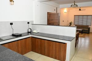 a kitchen with a counter top and a living room at Wayanad Farm Heritage in Sultan Bathery