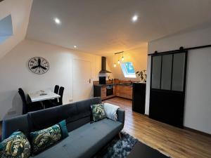 a living room with a couch and a table at Cocon de charme in La Chapelle-Gonaguet