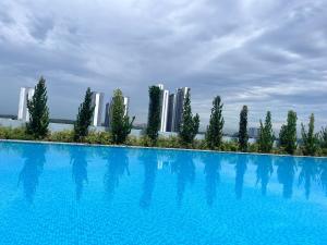 a large swimming pool with trees and buildings in the background at Edusphere near MMU UOC 2min Studio 2pax in Cyberjaya