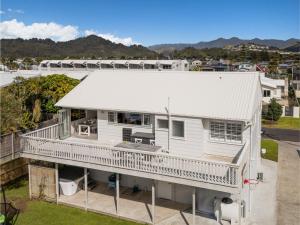 una vista aerea di una casa bianca con terrazza di Beverley Beach - Whangamata Holiday Home a Whangamata