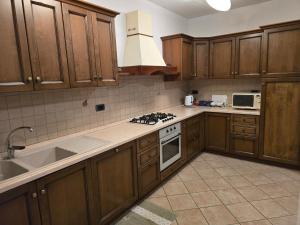 Una cocina con gabinetes de madera y un horno de estufa. en Appartamento Rosa, en Aosta 4 fotos más