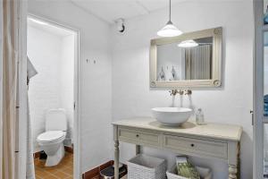 a bathroom with a sink and a toilet and a mirror at OH300-Hadsund-Ved-Mollen-3 in Hadsund +17 photos