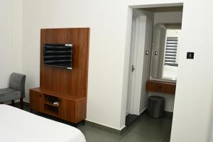 a bedroom with a bed and a cabinet and a mirror at Wayanad Farm Heritage in Sultan Bathery