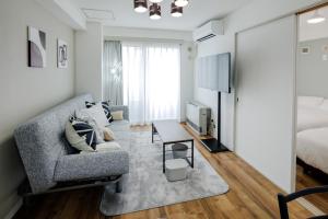 a living room with a couch and a tv at Sapporo Residence 14 in Sapporo