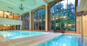 a large swimming pool in a large room with windows at Wille Bali Indah in Słupsk