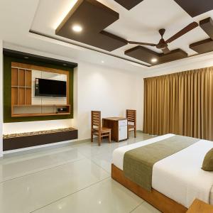 a bedroom with a bed and a desk and a tv at Rosa Mystica Hotels & Resorts in Anachal
