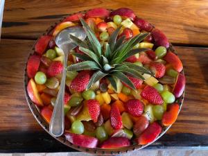 a bowl of fruit with a spoon on a table at Mohlabetsi Safari Lodge in Hoedspruit