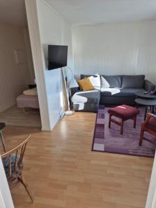 a living room with a couch and a table at Overnatting Kjøllefjord, Hybelleilighet med kjøkkenkrok og eget bad in Kjøllefjord