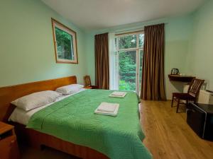 a bedroom with a green bed and a window at Nunisi Forest Hotel & SPA in Nunisi
