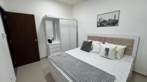a bedroom with a large bed with white sheets and pillows at Modern 2BR Resort Apartment with Pool & Gym, Malabe in Malabe