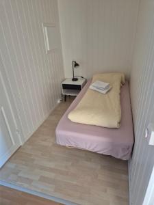 a small room with a bed and a lamp on a table at Overnatting Kjøllefjord, Hybelleilighet med kjøkkenkrok og eget bad in Kjøllefjord