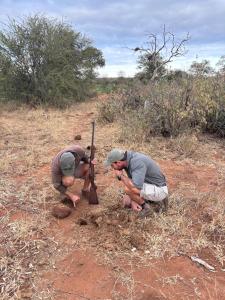 two men working on a pole in a field at Mohlabetsi Safari Lodge in Hoedspruit