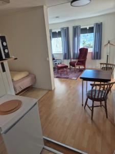 a kitchen and living room with a table and chairs at Overnatting Kjøllefjord, Hybelleilighet med kjøkkenkrok og eget bad in Kjøllefjord