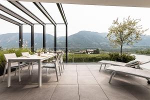 a patio with a table and chairs and mountains at Panorama Apartment in Nalles