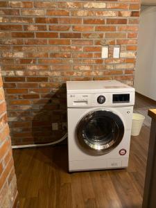 eine Waschmaschine neben einer Ziegelwand in der Unterkunft Charming Home with Rustic Brick Walls Quiet Area, 15 min to Gimpo Airport  + 3 Fotos