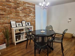 ein Esszimmer mit einem Tisch, Stühlen und einer Ziegelwand in der Unterkunft Charming Home with Rustic Brick Walls Quiet Area, 15 min to Gimpo Airport 