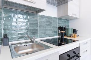 Una cocina con fregadero y una pared de azulejos verdes. en DUOMO Wonderful Apartment for 6, en Milán 27 fotos más