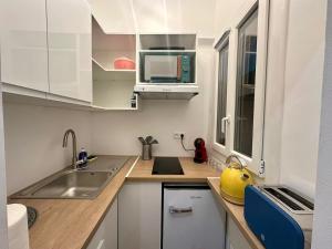 a small kitchen with a sink and a microwave at Studette tout équipée centre ville de Nice in Nice