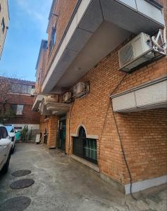 Un edificio de ladrillo con coches aparcados delante. en Stay Onjeong Jamsil Accommodation, en Seúl