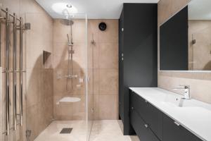 a bathroom with a glass shower and a sink at Panoramahytte med fjellutsikt in Sogndal +30 photos