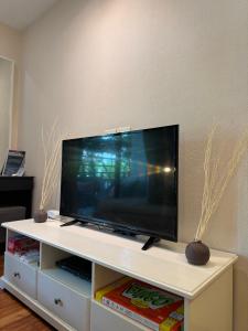 TV de pantalla plana en la parte superior de un centro de entretenimiento blanco en Pool Access Beachfront Studio, en Phuket 6 fotos más