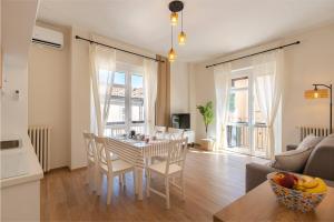 アスティにあるSella Suite Apartmentのテーブルと椅子のあるキッチンとリビングルーム