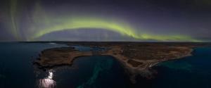 an island in the ocean with an aurora in the sky at The Nest in Raufarhöfn