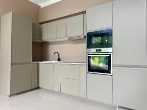 a kitchen with white cabinets and a sink at POSH VILLA, jungle view, pool, BanTai in Ban Nua