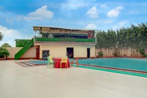 un patio avec une table et une piscine dans l'établissement Collection O Sun Temple Gwalior Formerly Sunshine Resort, à Gwalior