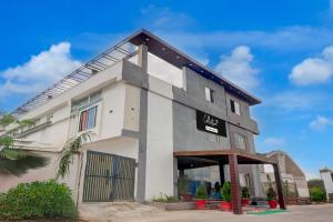 un bâtiment blanc avec un panneau dessus dans l'établissement Collection O Sun Temple Gwalior Formerly Sunshine Resort, à Gwalior