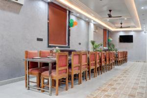 une salle à manger avec une longue table et des chaises dans l'établissement Collection O Sun Temple Gwalior Formerly Sunshine Resort, à Gwalior