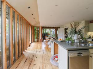 a kitchen with wooden flooring and a hallway with windows at Headland Barn in Maldon