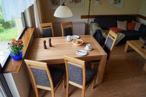 un salon avec une table et des chaises en bois dans l'établissement Ferienhaus Wieselweg im Feriendorf Reichenbach 1, à Nesselwang