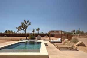 a swimming pool with two lounge chairs next to at Sol e Cielo Casa Dua by Fieldtrip in Yucca Valley