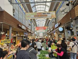 a crowd of people walking around a market with vegetables at Gongrim Stay in Seoul