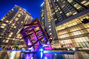 a purple sculpture in front of tall buildings at night at Highland Breeze Hotel in Genting Highlands