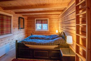 ein Schlafzimmer mit einem Bett in einer Holzhütte in der Unterkunft Trysilfjellet Nord 901 in Trysil