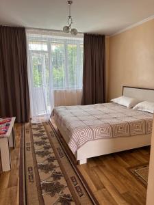 a bedroom with a bed and a large window at Boomerang Guest house in Cholpon-Ata +29 photos