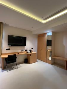 a room with a desk and a television on the wall at Nirvana Nest in Lucknow +14 photos