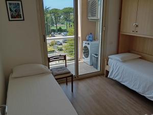 a room with two beds and a door to a balcony at Modern and bright apartment in Rome