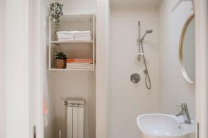 a white bathroom with a sink and a shower at Regina 144 by RD Domus in Turin