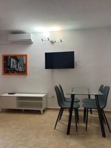 une salle à manger avec une table et des chaises et une télévision dans l'établissement San Juan Beach Bungalow - Muchavista, à San Juan de Alicante