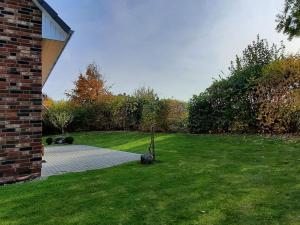 a small tree in the grass next to a house at Schneckenhaus Ferienhaus in Groß Schwansee