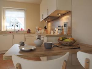 a kitchen with a table with a bowl of fruit on it at Schneckenhaus Ferienhaus in Groß Schwansee