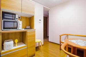 a kitchen with a counter with a microwave and a table at Sunflower Hotel 703, Osaka, Namba & Shinsaibashi in Osaka +25 photos