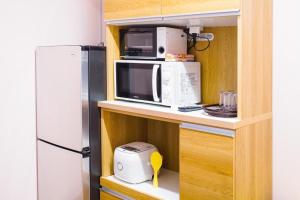 a kitchen with a microwave and a refrigerator at Sunflower Hotel 703, Osaka, Namba & Shinsaibashi in Osaka