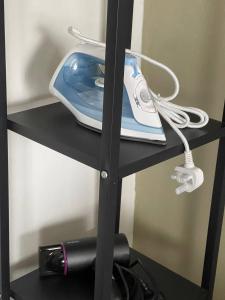 a black shelf with a iron and a phone on it at MKB Homestay - 2 X Queen Bed Studio Room with View and Free Parking in Klang +2 photos