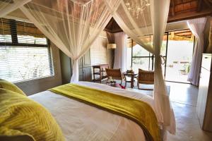 a bedroom with a large bed with a canopy at Mohlabetsi Safari Lodge in Hoedspruit