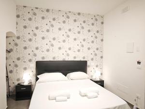 una camera da letto con un letto con due asciugamani bianchi di Raggio di Sole 3 a Bari