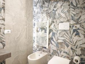 bagno con servizi igienici e parete decorata con fiori di Raggio di Sole 3 a Bari